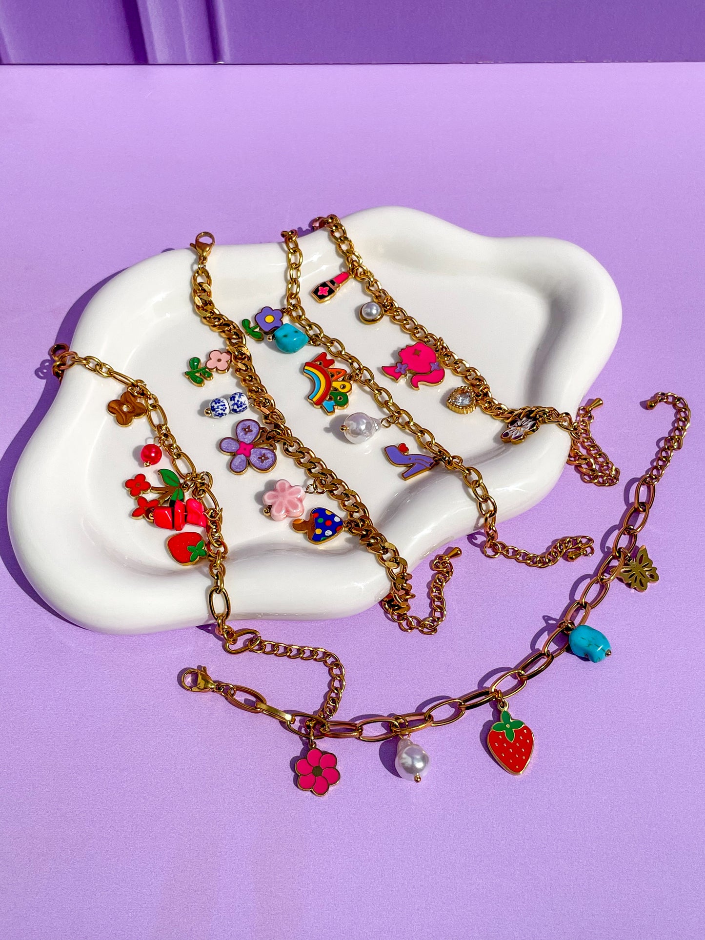 Pulseras charms, lipstick, barbie