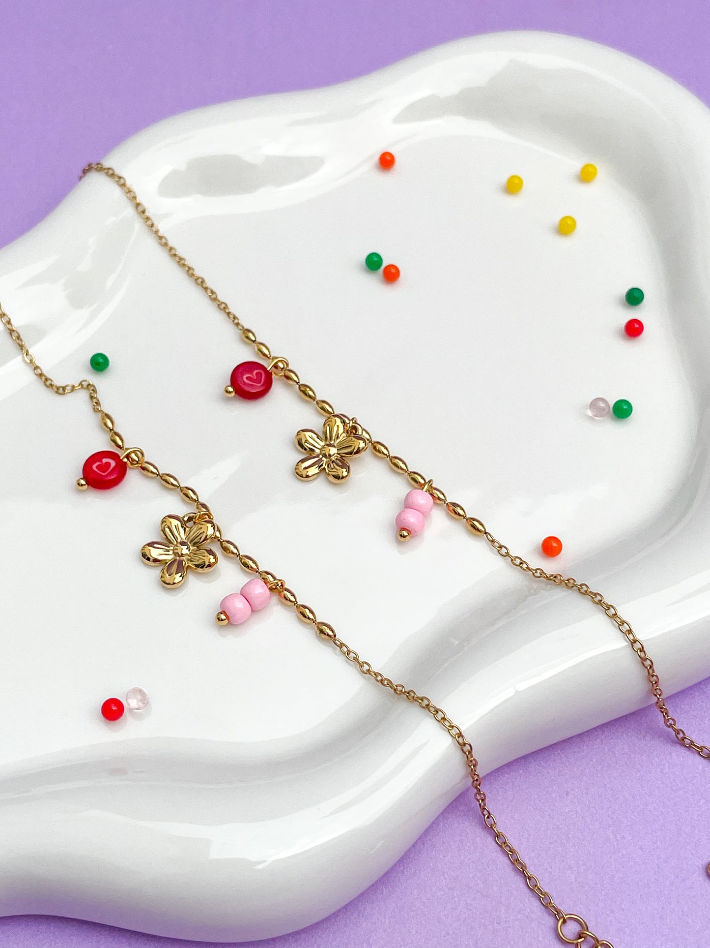 Pulsera charms flor dorada, con piedra roja