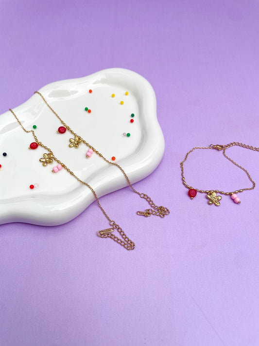 Pulsera charms flor dorada, con piedra roja